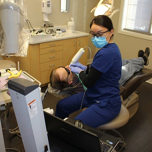 Dental team member capturing smile images during dental checkup