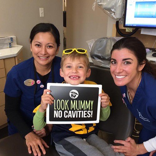Dental team members and young patient during children's dentistry visit