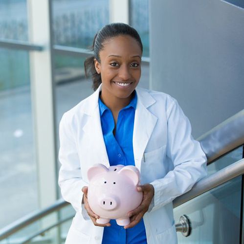 implant dentist in Willowbrook holding a pink piggy bank 
