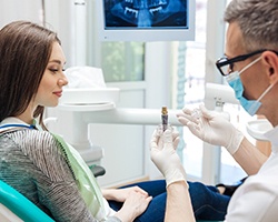 dentist showing a dental implant to a patient 