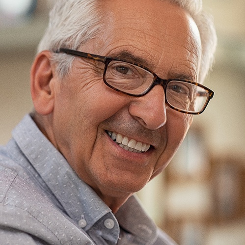 Older man with dental implants in Willowbrook smiling