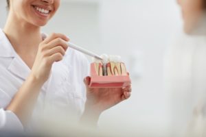 woman holding dental implant model
